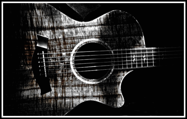 A black and white photo of my Taylor Koa K22 with lots of textured shadows