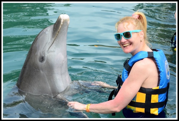 Sarah stood on the right holding both flippers whilst having a dance with the dolphin
