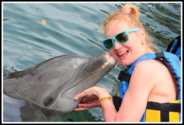 Sarah getting a kiss from the dolphin