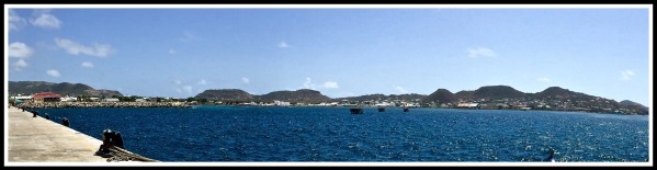 A panorama taken from the dock pier overlooking the amazing span of volcano hills with the vivid blu sea in front