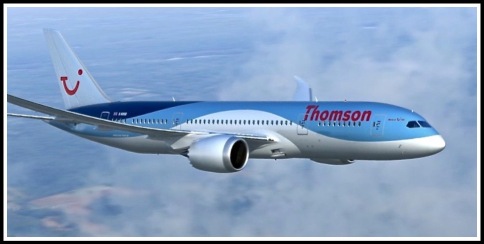 A photo of the Thomson 787 Dreamliner in flight above the clouds, flying from left to right