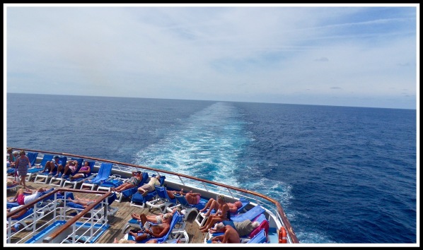 A view of the ocean from the rear of the ship, overlooking the sunbathing area at the bottom of the shot