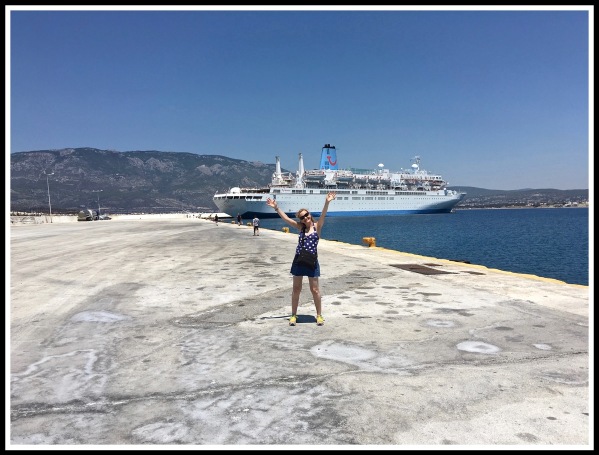 Sarah stood in front of the Thomson Spirit shipwith both arms in the air