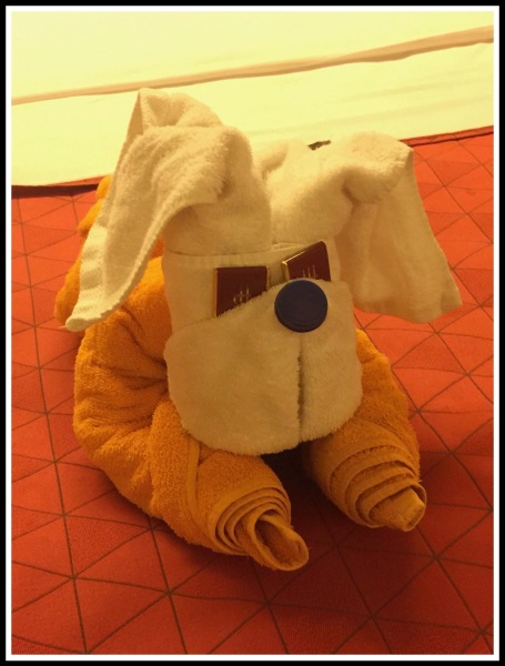 A towel folded into a puppy dog with chocolates as his eyes